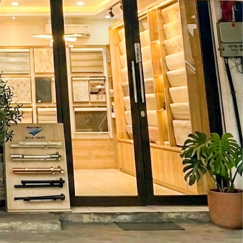 Bagian dalam showroom Evita Interior dengan rak contoh wallpaper dan contoh rel gordyn