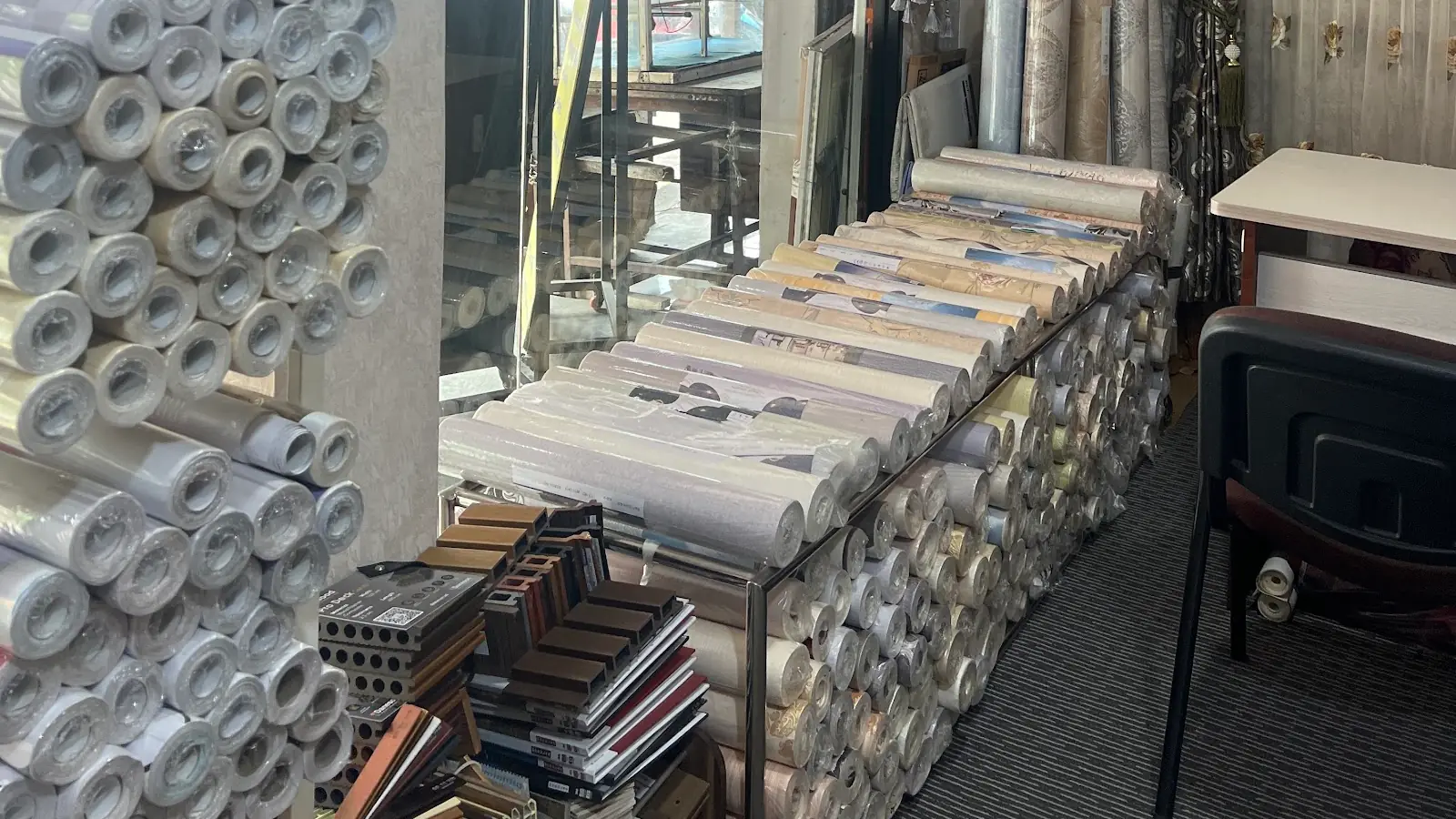 Gulungan contoh wallpaper dan sampel panel di showroom Evita Interior